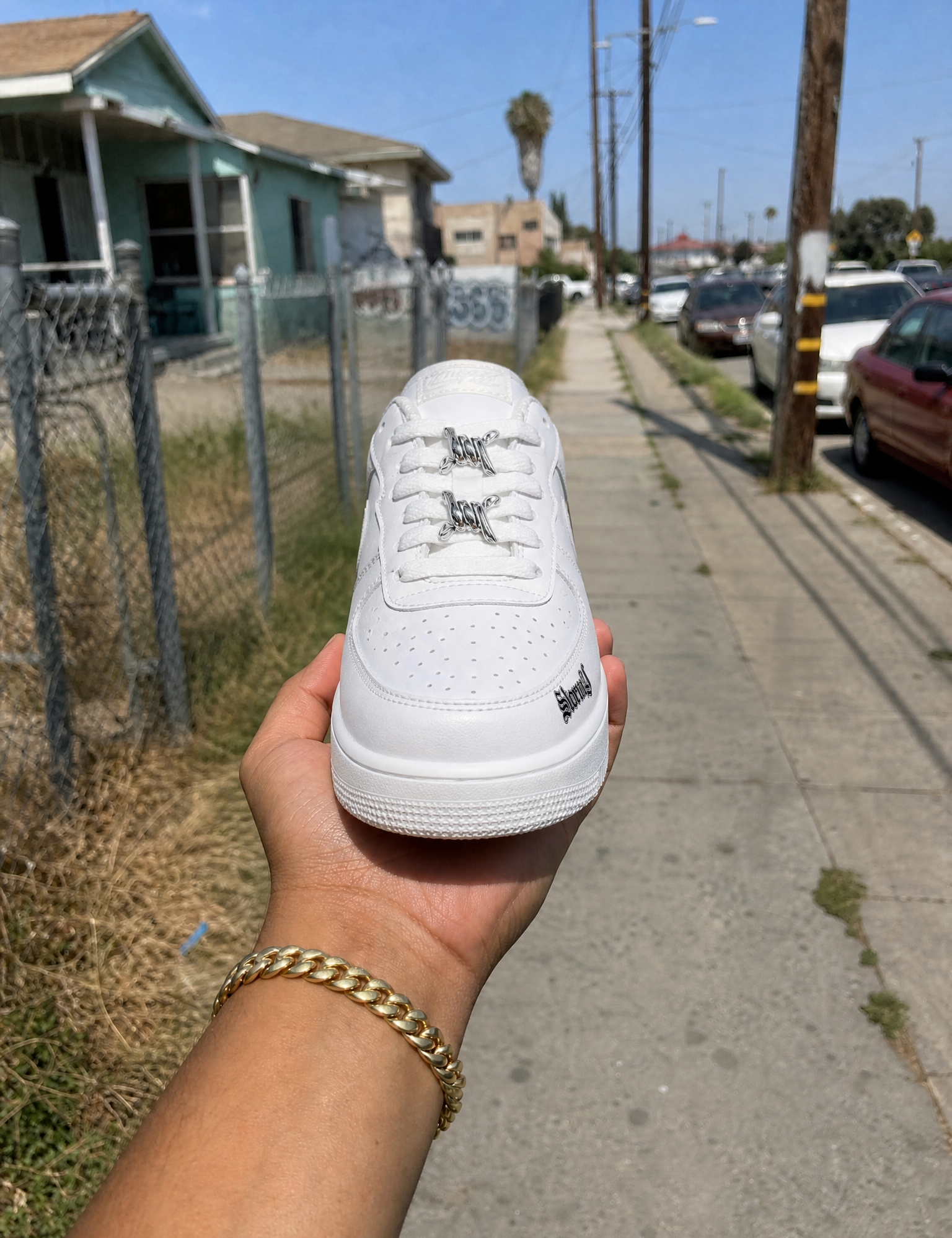 Generated_with_Kive.ai_-_White_leather_sneaker_Use_the_provided_reference_image_as_the_composition_reference_for_the_scene._Preserve_the_exact_same_hand__hand_position__grip__wrist_an_e8dfe74f-23a1-4b51-97c4-848ea5b9cd5c.png